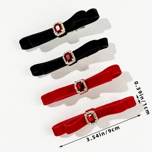 Detail view of velvet bow hair clips with red ruby center and sparkling gemstone border