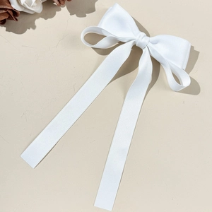 Détail de la pince à cheveux nœud blanc avec de longs rubans élégants en tissu doux