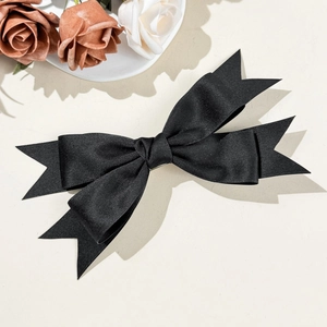 Close-up of elegant double-layered black satin bow hairclip with classic dovetail design