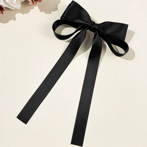 Détail du nœud papillon en soie noire avec une texture satinée mate et lisse