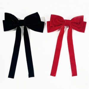 Large velvet bow hair clips in black and red with long ribbons for elegant hairstyling