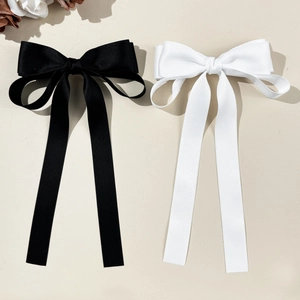 Barrettes élégantes avec nœuds en satin noir et blanc et longs rubans en vue de dessus