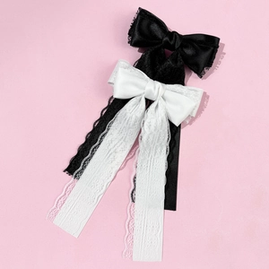 Detailed view of black and white lace bow hair clips with long satin streamers