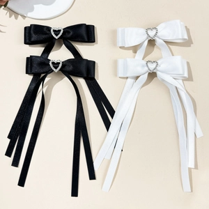 Detail of silk bow hair clips with silver heart rhinestones and long ribbons