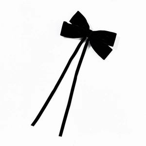Detailed view of the double-layered black velvet bow hairclip with long hanging ribbons