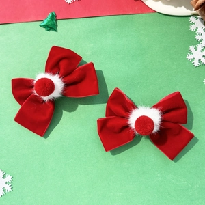 Detail of red velvet hair clips with white faux fur pom-poms for Chinese New Year styling