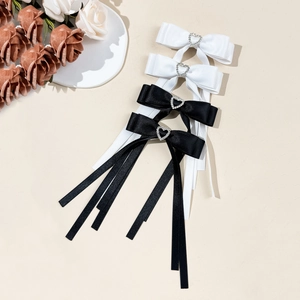 Set of black and white satin bow hair clips with heart rhinestones and long streamers