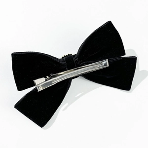 Elegante fermaglio per capelli a fiocco in velluto nero con perla su sfondo bianco