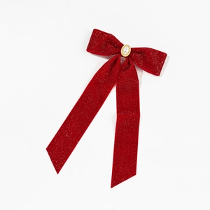 Detail of red velvet bow hair clip with shimmering glitter and center faux pearl inlay