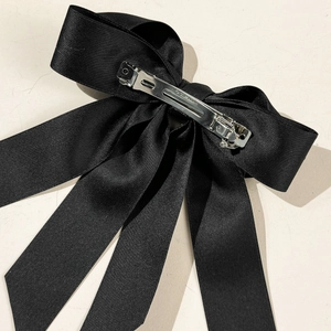 Détail du nœud en satin noir élégant avec fermoir métallique argenté gravé Paris