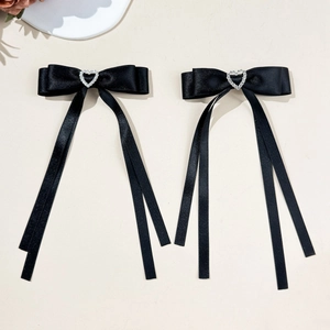 Detail of black satin bow hair clips with heart rhinestone and long silk ribbon tassels