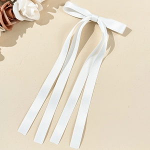 Détail d'un nœud papillon en satin blanc avec de longs rubans fluides élégants