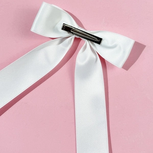 Elegant white satin ribbon bow hair clip with silver metal duckbill clip on pink base