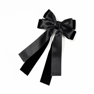 Detail showing layers of black satin and velvet ribbon on a classic bow hair clip