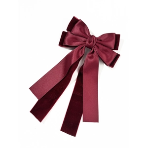 Detail of elegant wine red double-layered bow hair clip with silk and velvet ribbons