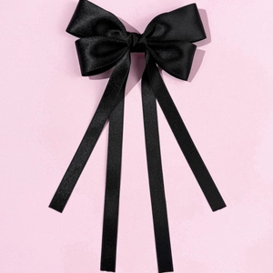 Detail view of the elegant black satin double-layered bow hair clip with long ribbons