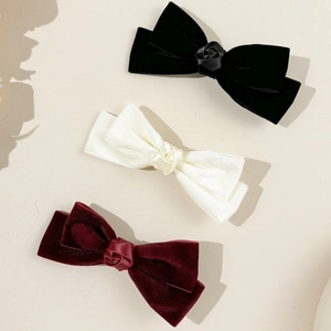 Three-piece velvet bow hair clips with satin roses in black, cream, and wine red colors