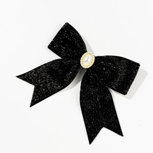 Détail du nœud à cheveux en velours noir avec perle ovale et ornements en strass brillants