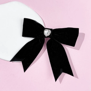 Macro shot of black velvet bow hair clip with a sparkling rhinestone heart centerpiece