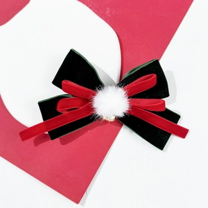 Velvet bow hair clip with white pompom in festive red and green for Christmas style