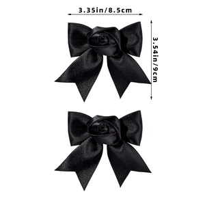 Detail view of two black satin ballet-style hair clips with rose center and bow design