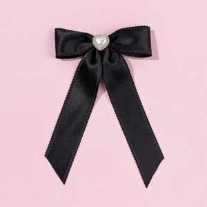 Détail du nœud en satin noir avec perle en cœur et rubans ornés de strass