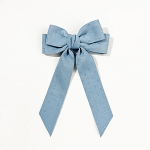Détail d'un nœud papillon en denim pour cheveux avec pois argentés et rubans