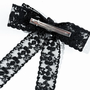 Dettaglio di un fiocco per capelli in pizzo nero con clip a coccodrillo in metallo sul retro
