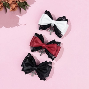 Gothic lace bow hair clips set with silver metal cross pendants on a pink background