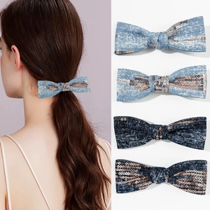 Detail of denim bow hair clips with sequins showing light and dark blue styles