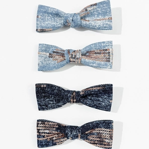 Detail showing denim fabric texture and rose gold sequins on handmade bow hair clips