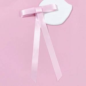 Détail du nœud de cheveux en satin rose avec de longs rubans sur un fond élégant