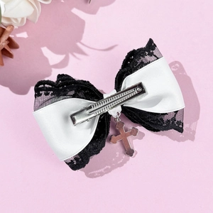 Detail of Gothic lace bow hair clip featuring a silver metal cross pendant and metal duckbill