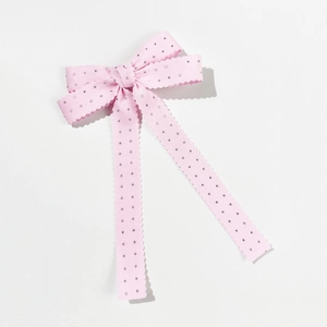Detail einer rosa Schleifen-Haarspange mit Wellenstruktur und silbernen Strasssteinen