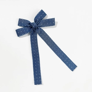 Detailansicht der blauen Denim-Haarschleife mit weißen Punkten und Wellenkanten