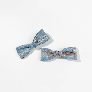 Detail of light blue denim hair bows with bronze sequins and fine fabric texture