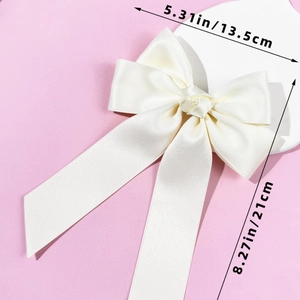 Détail du nœud en satin crème montrant les dimensions de 13,5 cm de large et 21 cm de long