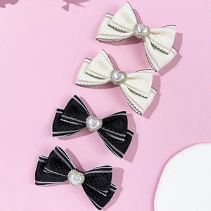 Lot de 4 barrettes nœuds avec perles de cœur et strass sur fond rose tendre