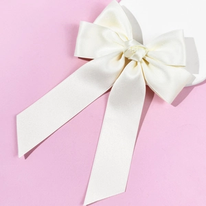 Vue détaillée du nœud de cheveux en satin blanc crème élégant avec finition soyeuse