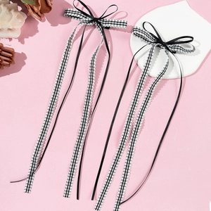 Detail of plaid bow hair clips with long ribbons and delicate white lace edges
