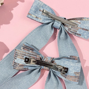 Detail of blue denim hair clips with rose gold sequins and silver metal spring fasteners