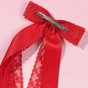Detail view of the silver alligator clip and delicate lace stitching on red bow hair clip