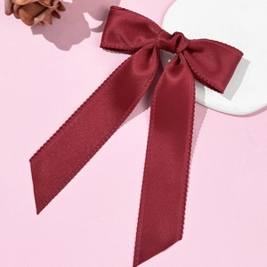 Barrette nœud élégante en satin bordeaux avec coutures sur fond rose pastel