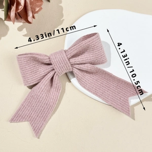 Close-up of pink knit bow hair clip with streamers showing fine braided texture and 11cm size