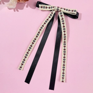 Detail of floral lace hair clip with embroidery and satin ribbons in French retro style