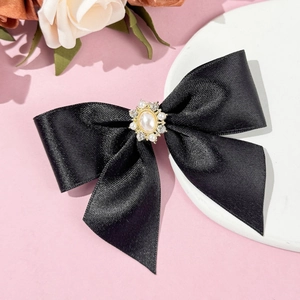Détail d'un nœud papillon en satin noir avec perle ovale et ornements en strass brillants