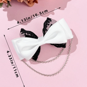 Nœud en dentelle avec chaînes argentées mesurant 10,5 cm sur 11 cm sur fond rose
