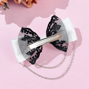 Gros plan d'un nœud papillon en satin blanc avec dentelle noire et double chaîne en métal