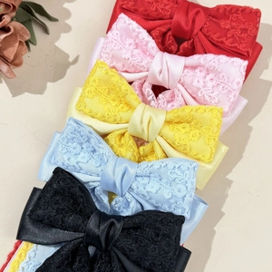 Detail of five-color lace bow hair ties featuring satin base and delicate floral textures