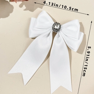 Detail showing white satin bow hair clip with crystal rhinestone center in 10.5cm width